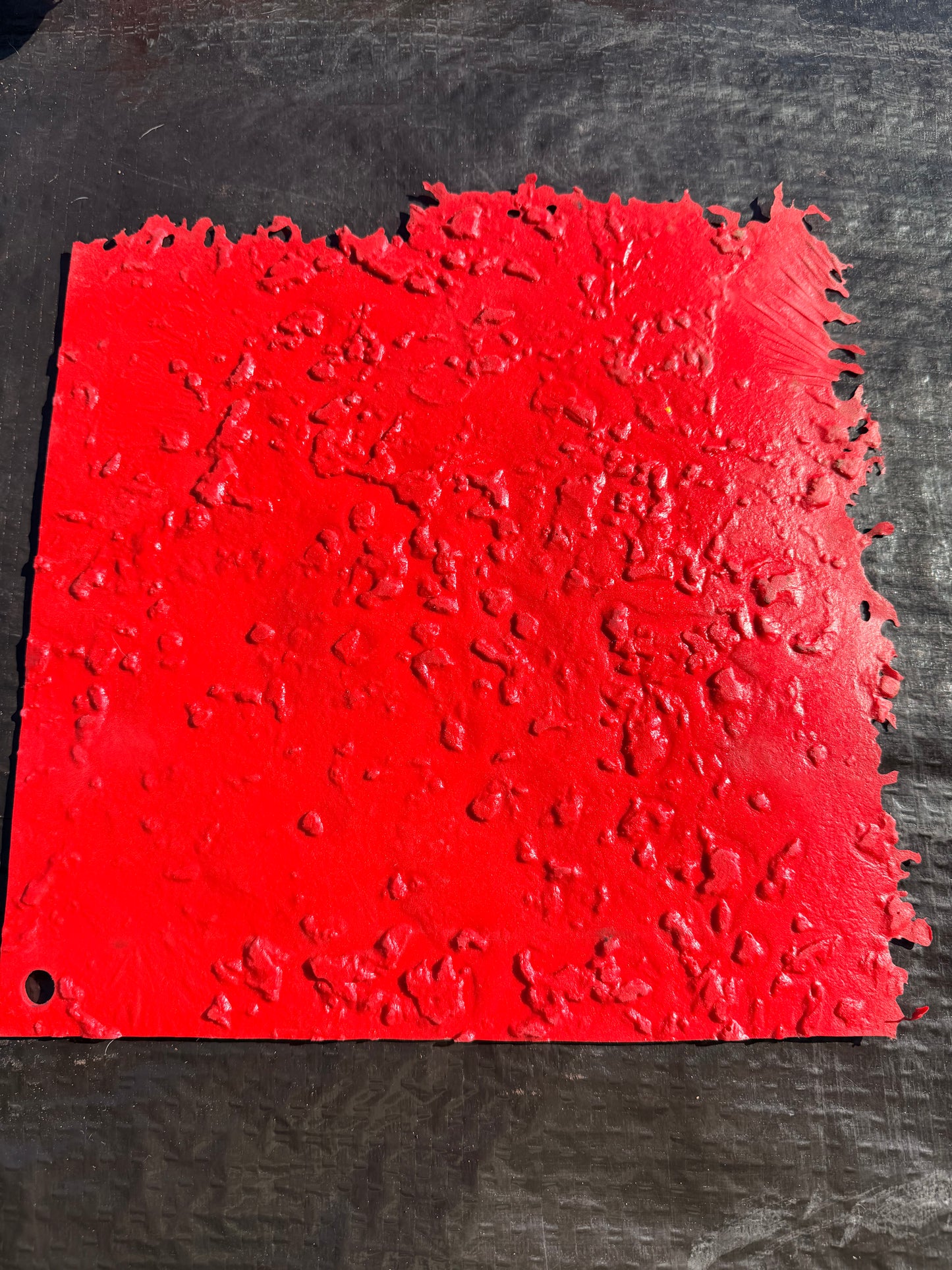 red square concrete mat on top of a black surface