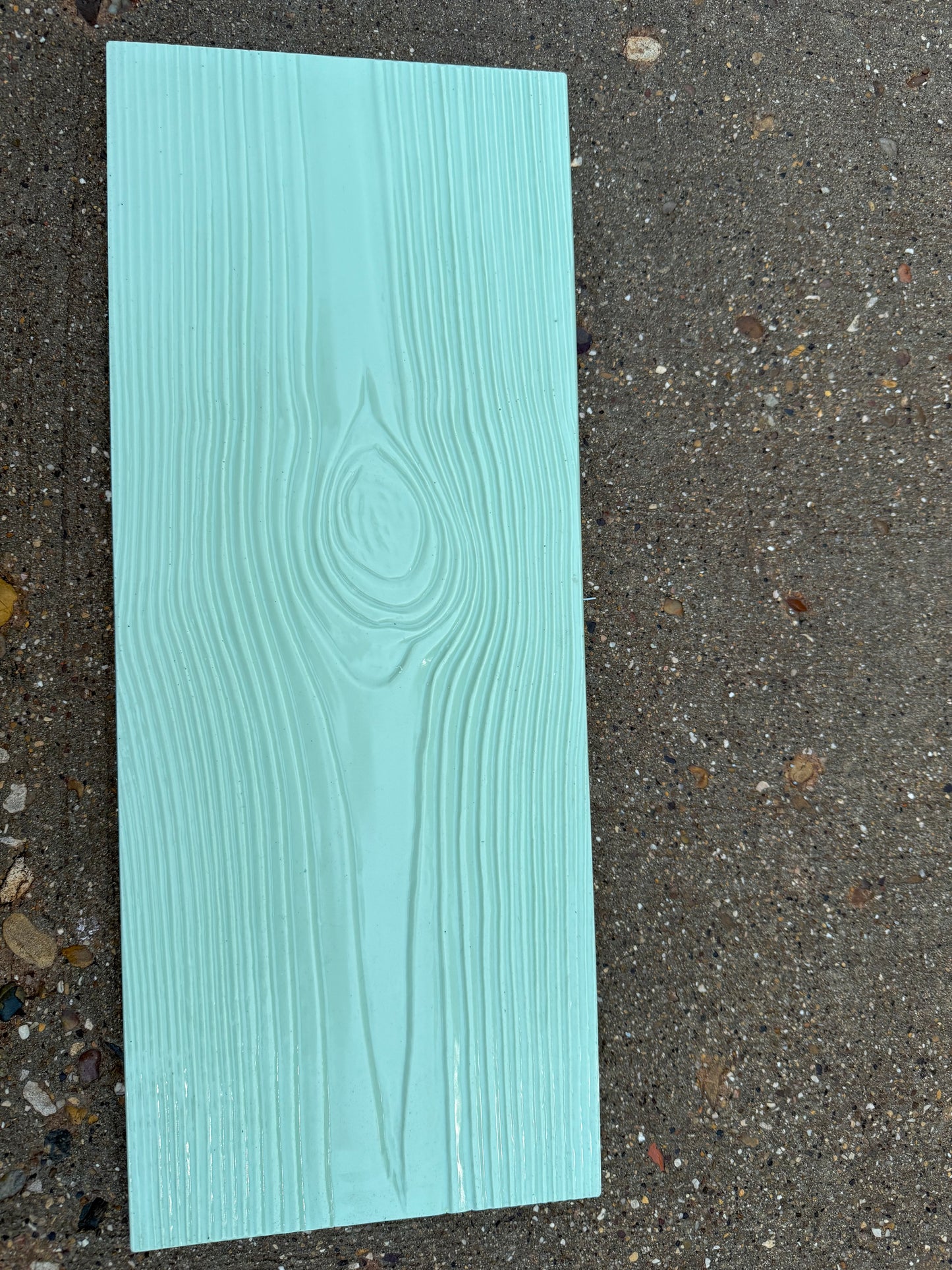 Teal wood-patterned concrete stamp on a concrete surface
