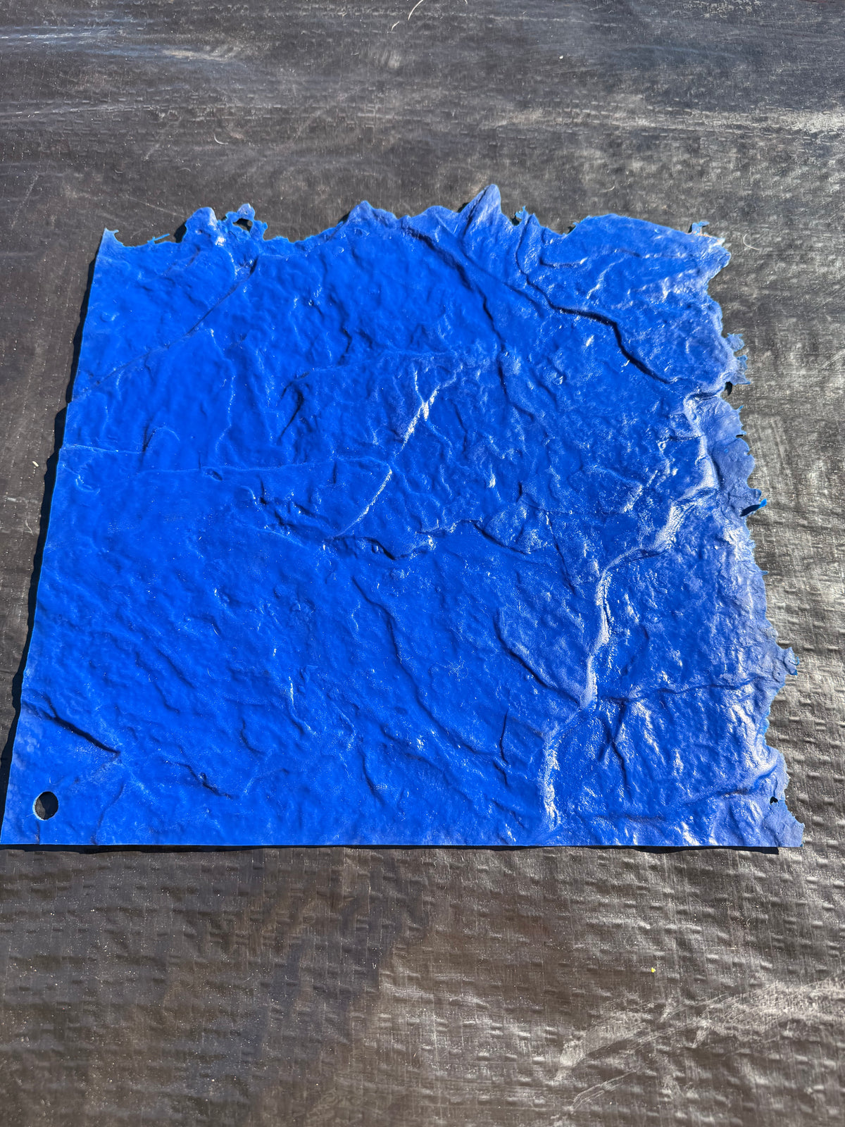 Blue textured concrete mat on a black surface