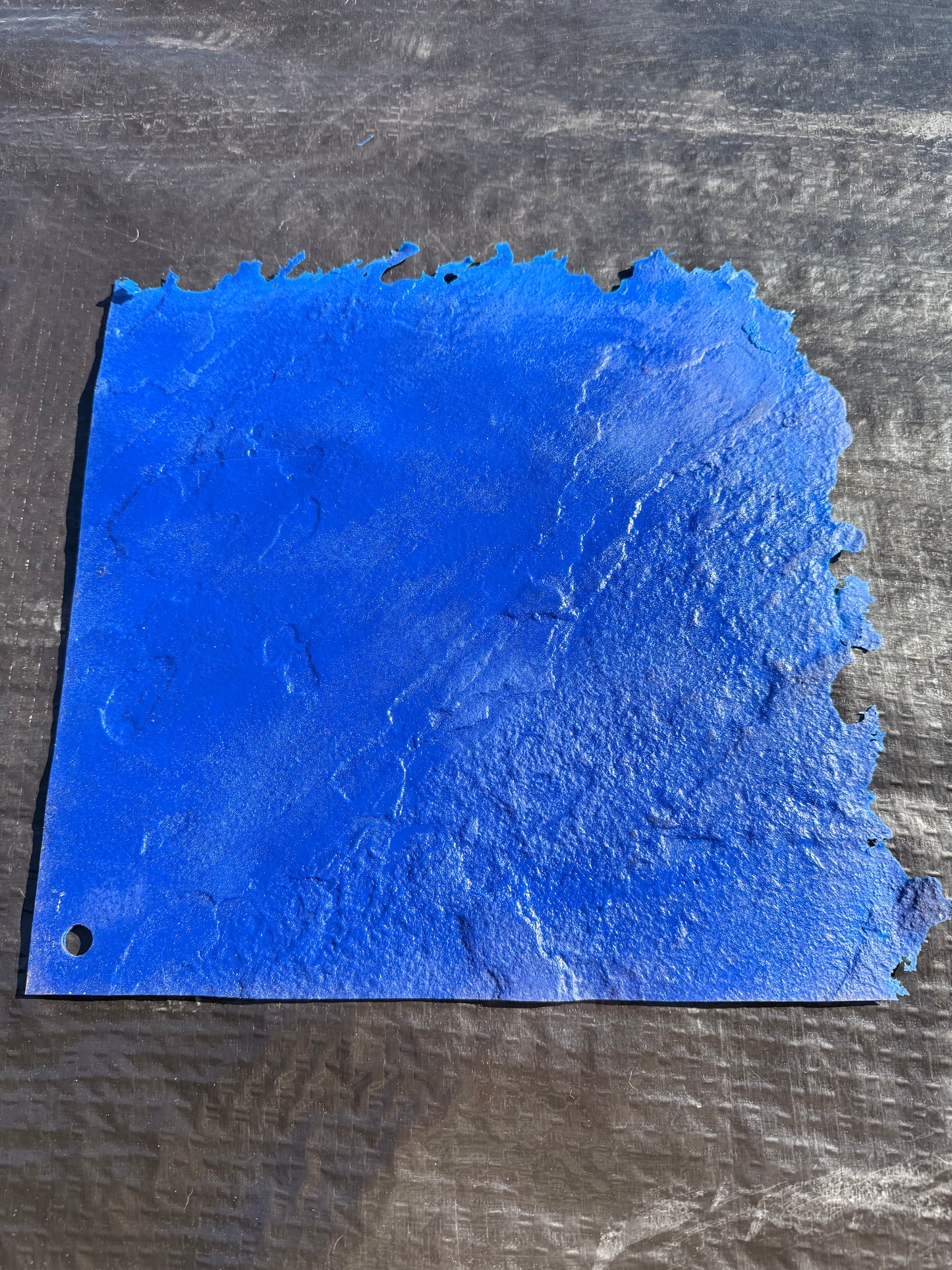 Blue textured concrete mat on a black surface 