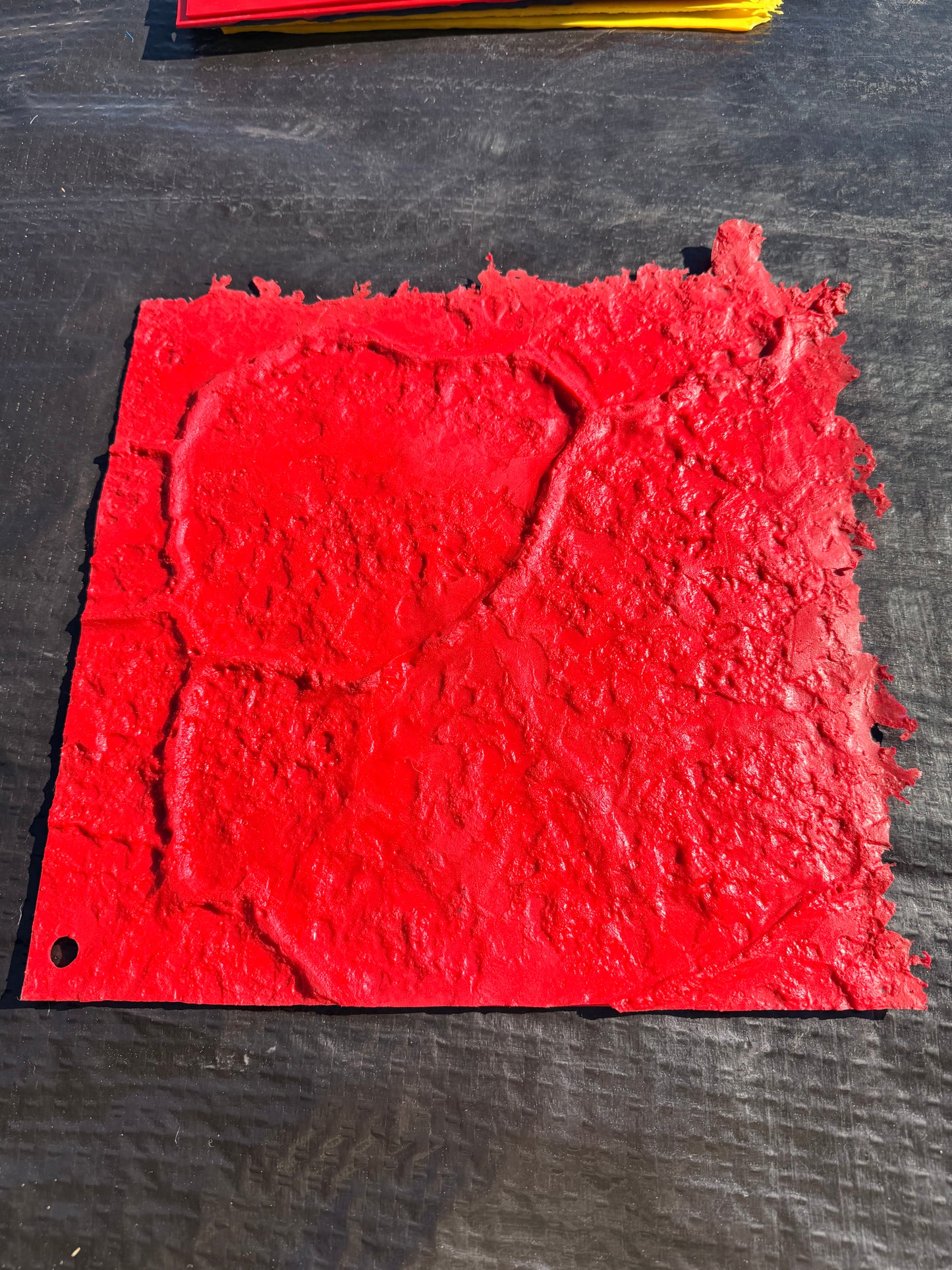 Red textured square on a dark background