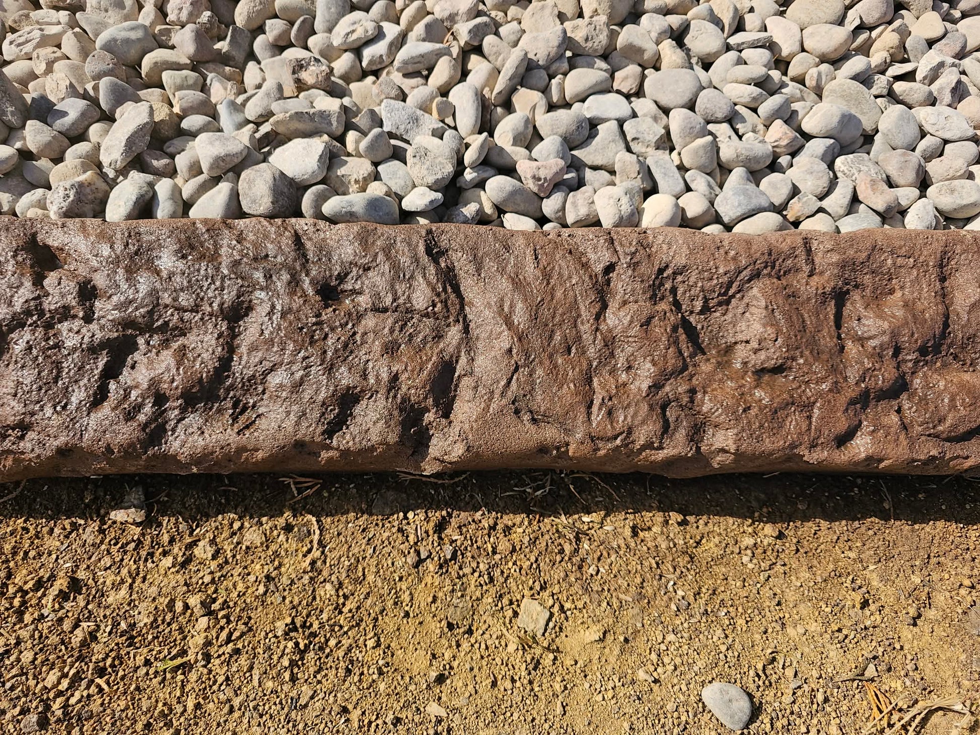 Rustic stone border on a gravel and dirt background
