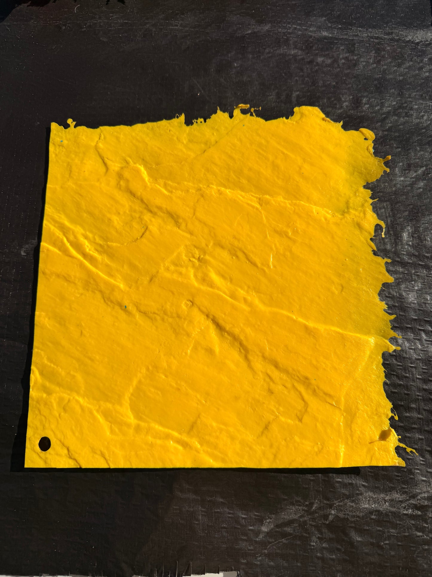 yellow square mat on top of a black surface