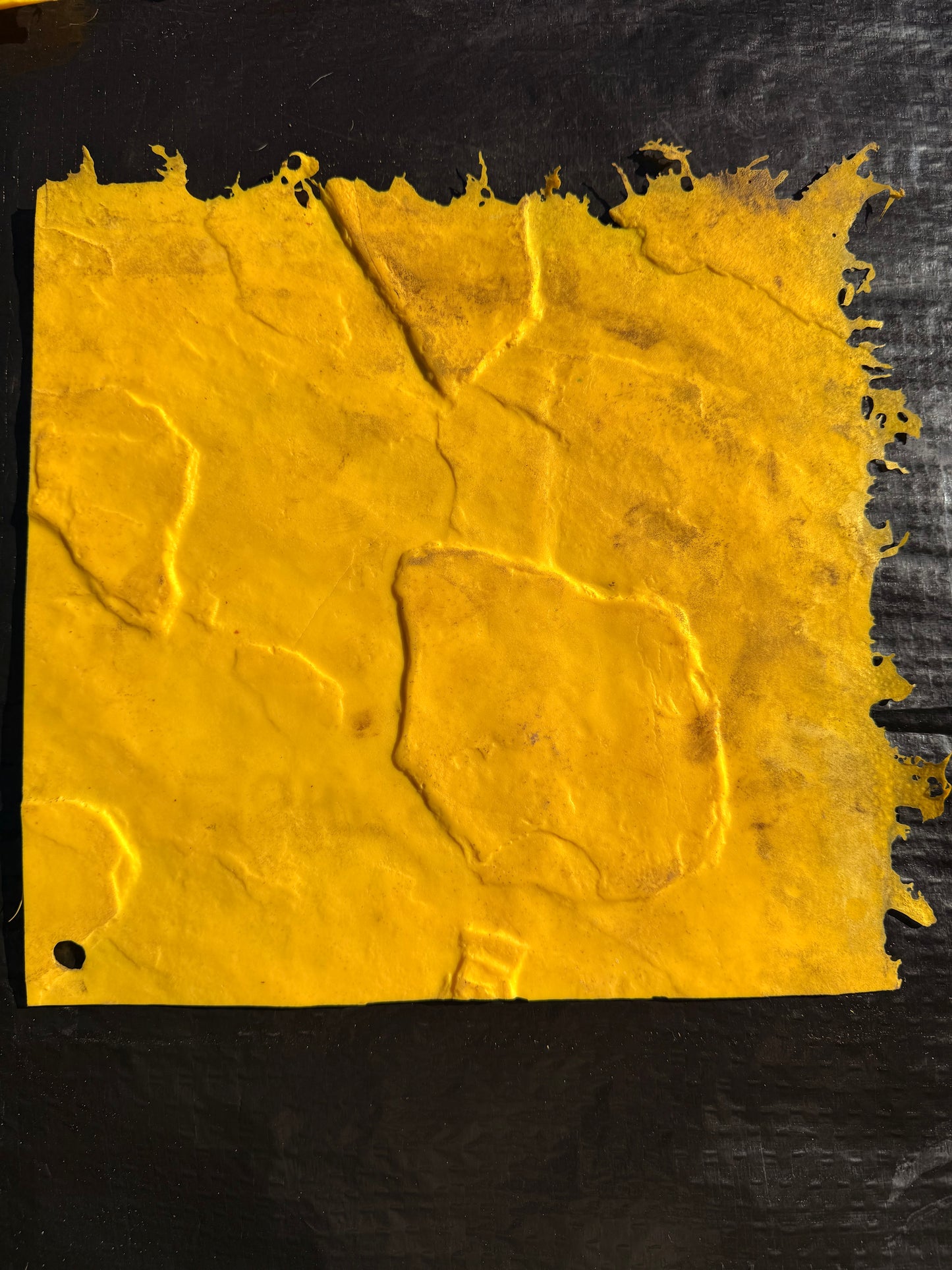yellow square textured concrete mat on top of a black surface