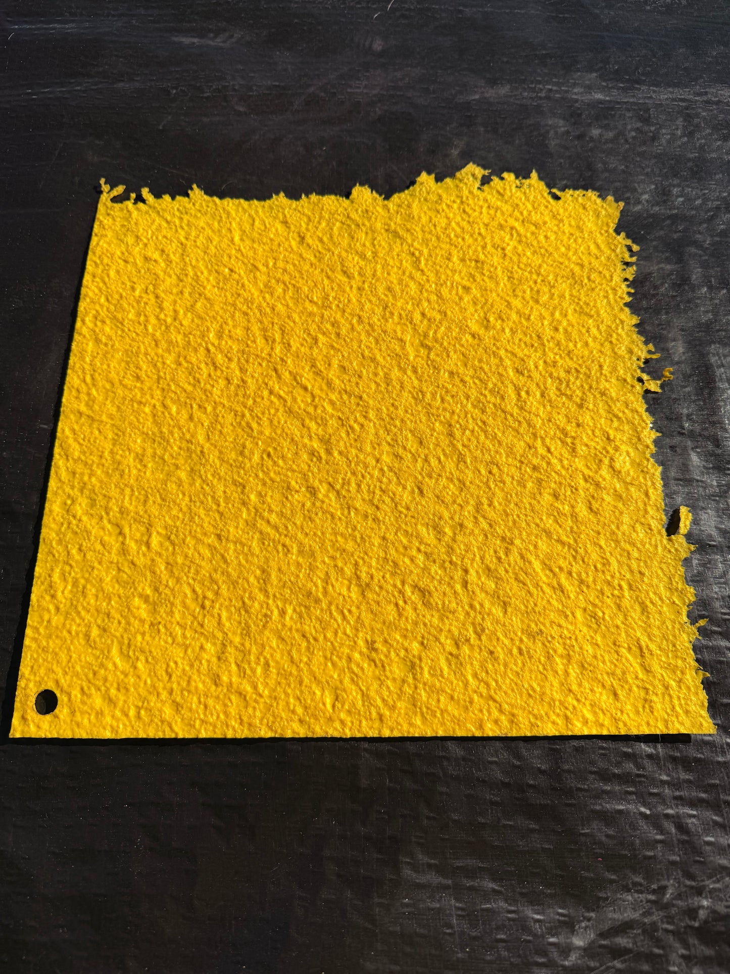 Yellow textured concrete mat on a black background