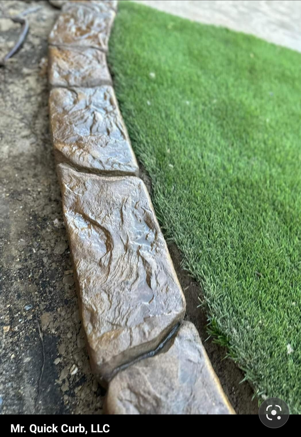 Oklahoma blue slate curbing along some green turf with some deep black joint lines top view.