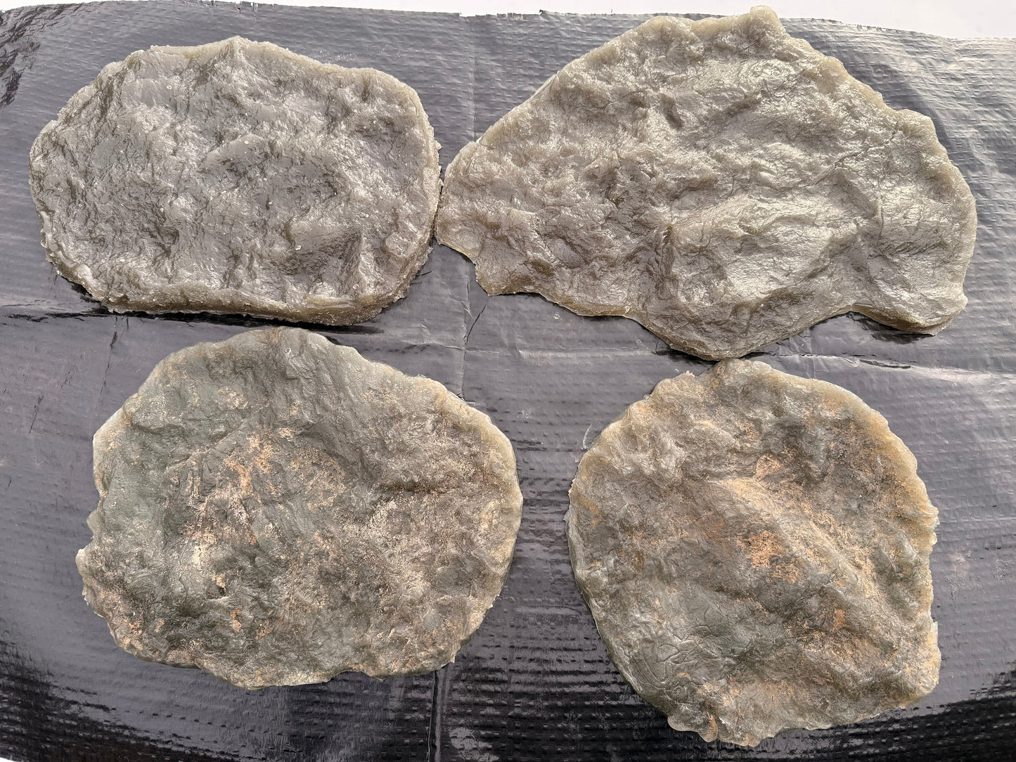 Four rough textured stamps on a dark surface