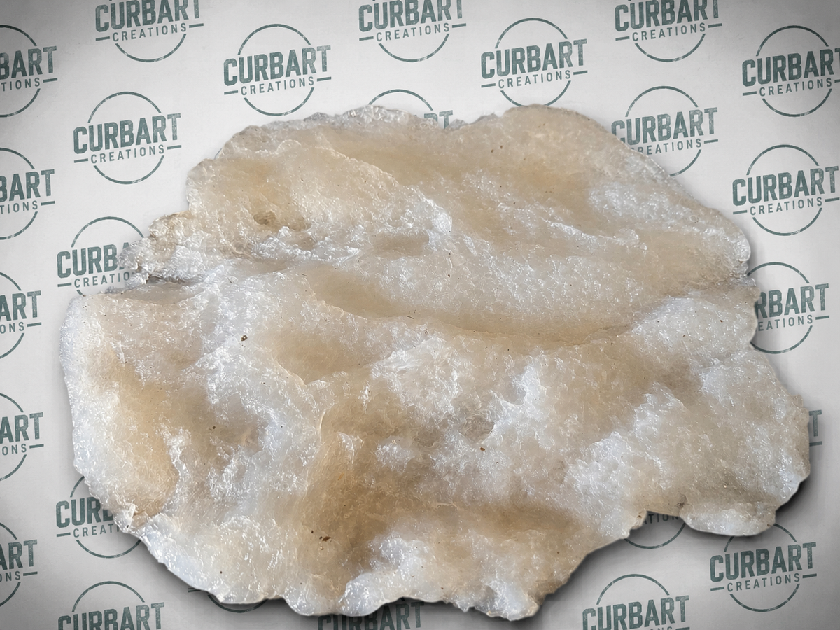 A  Post Canyon Stone Textured skin organic shape, featuring a mix of milky white and warm beige tones, displayed on a branded Curbart Creations background.