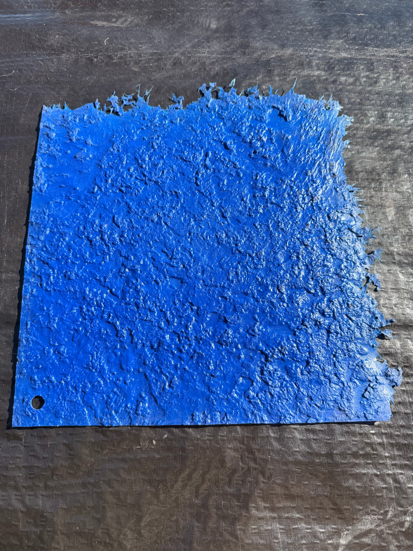 blue square mat on top of a black background surface