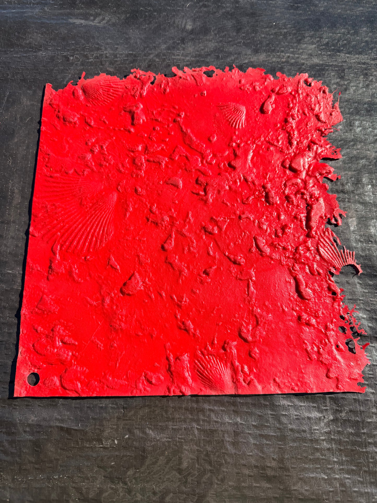 Red textured concrete mat on a dark background