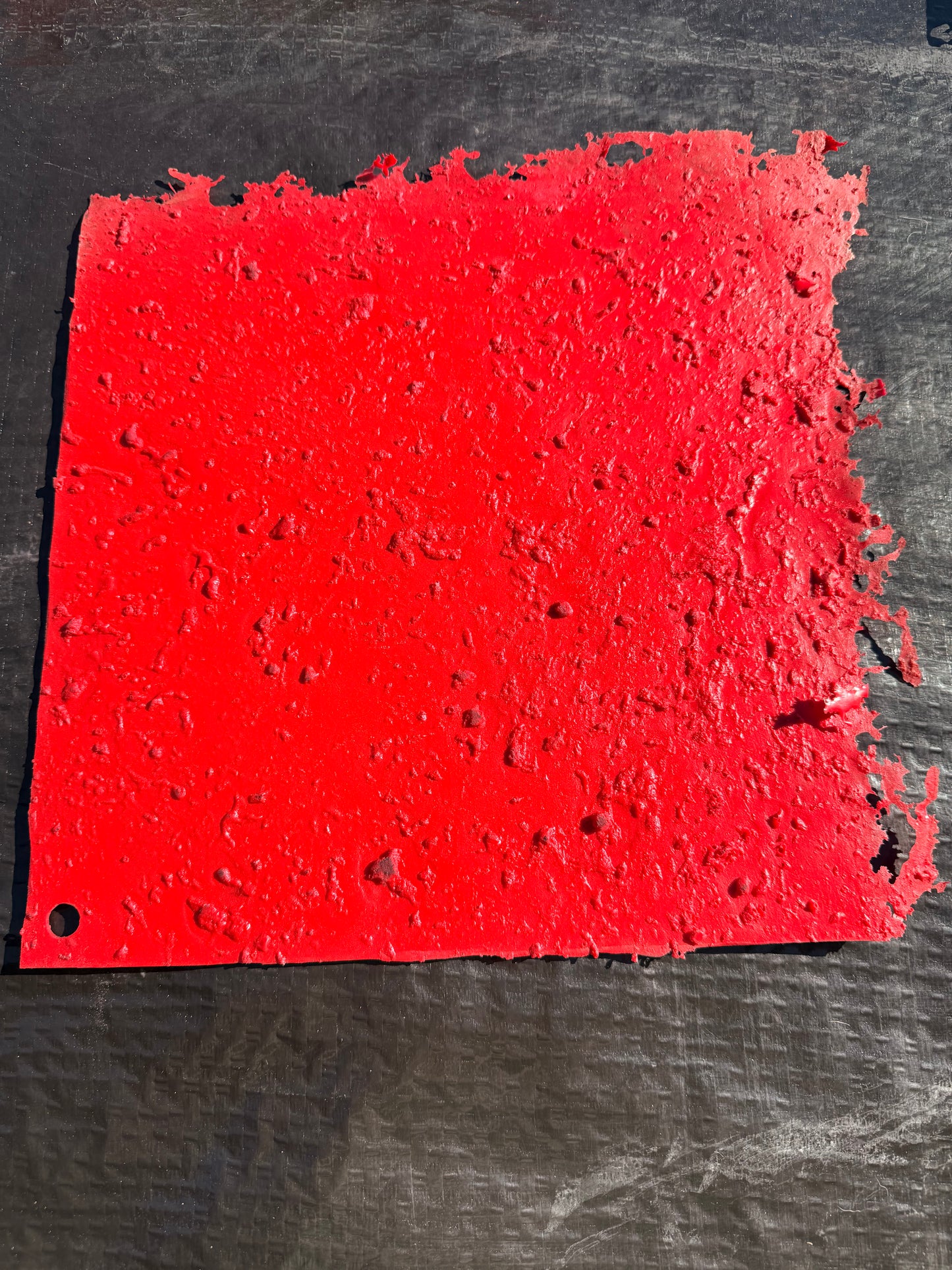 red square concrete mat on top of a lack surface