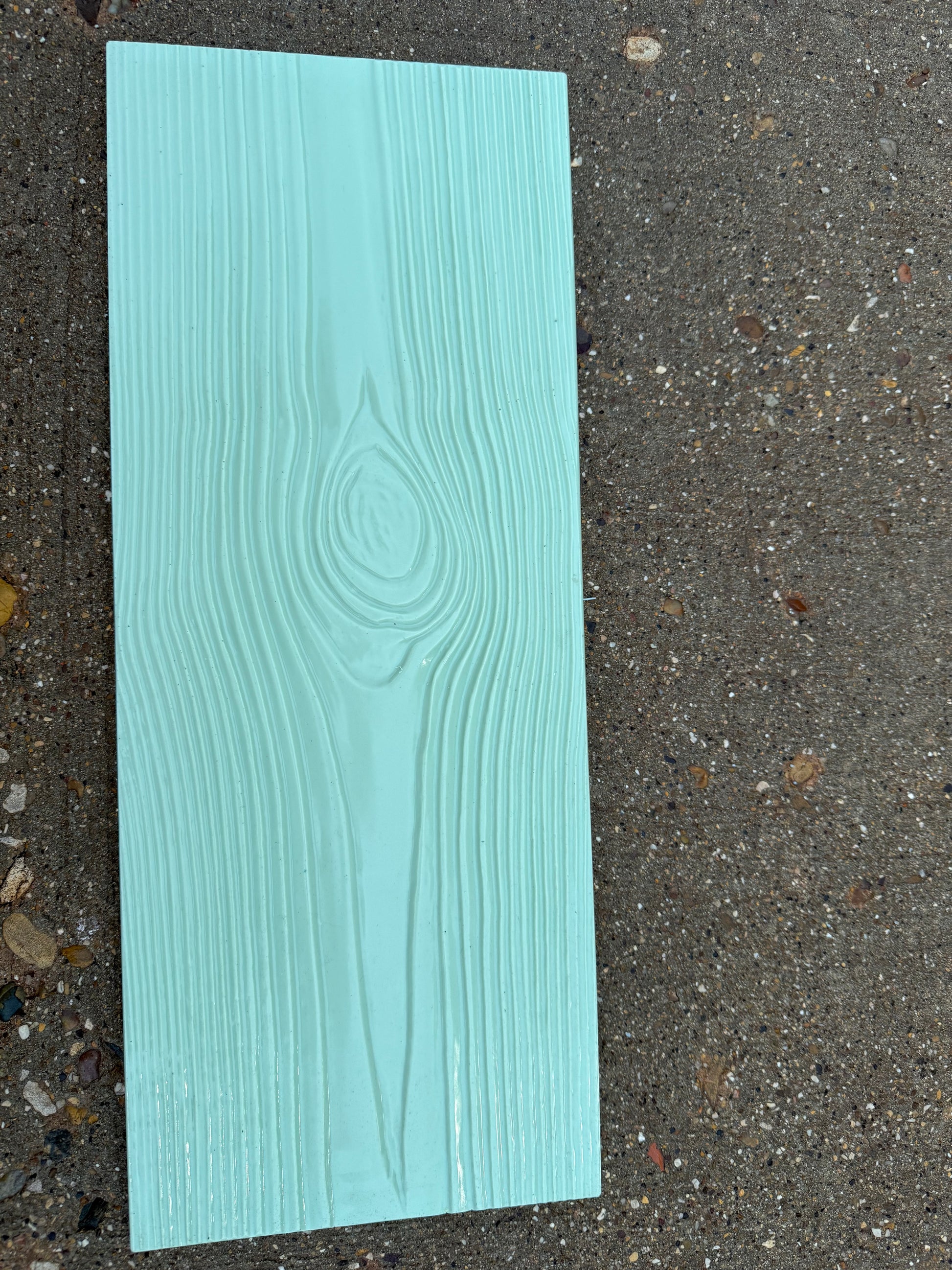 Teal wood-patterned concrete stamp on a concrete surface