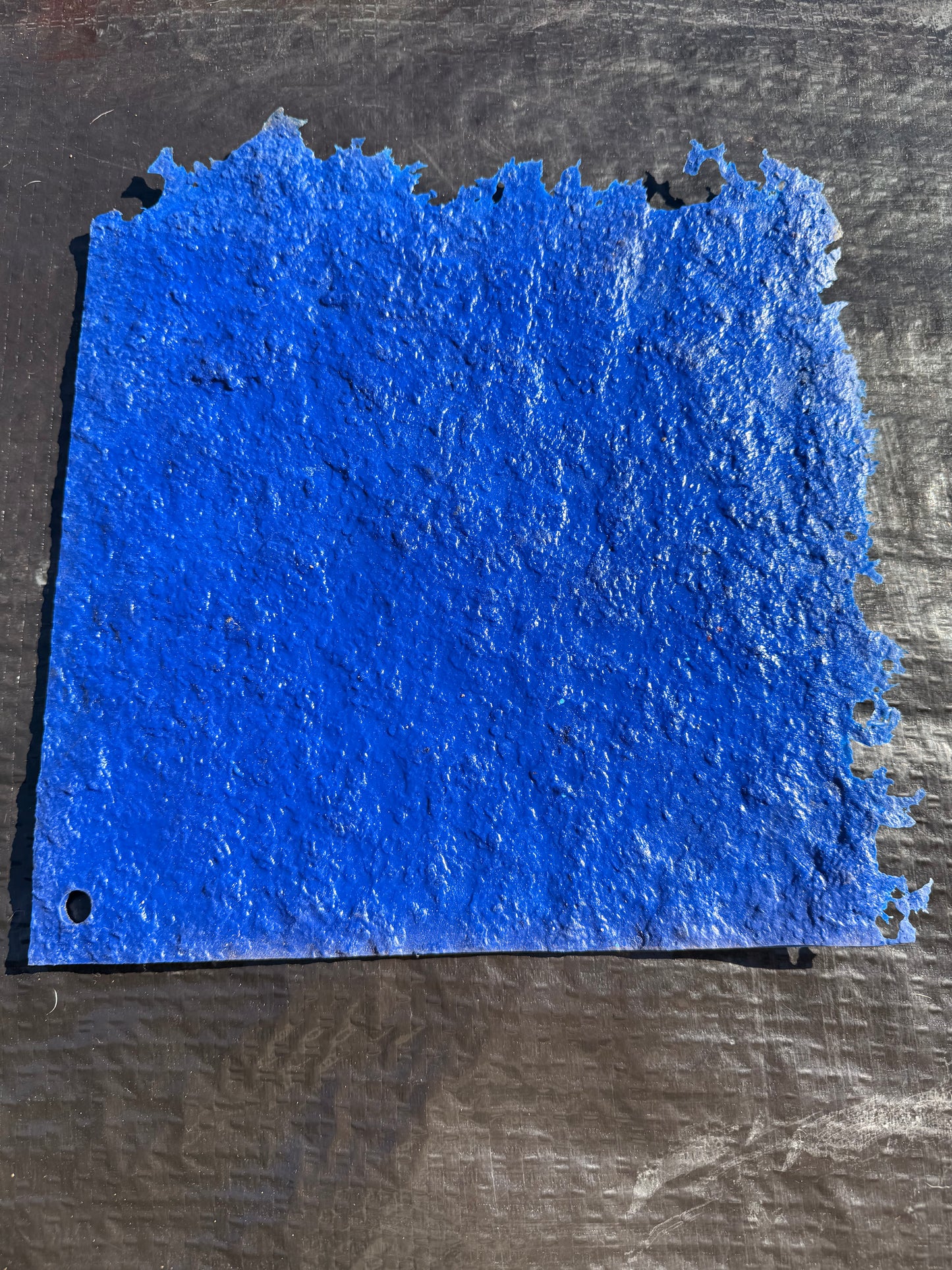 blue square concrete mat on top of a black surface