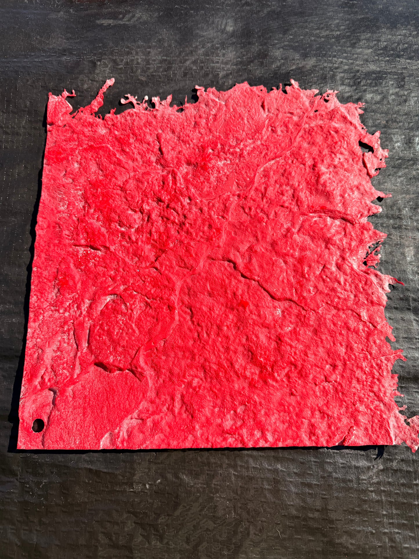 Red textured square on a black background