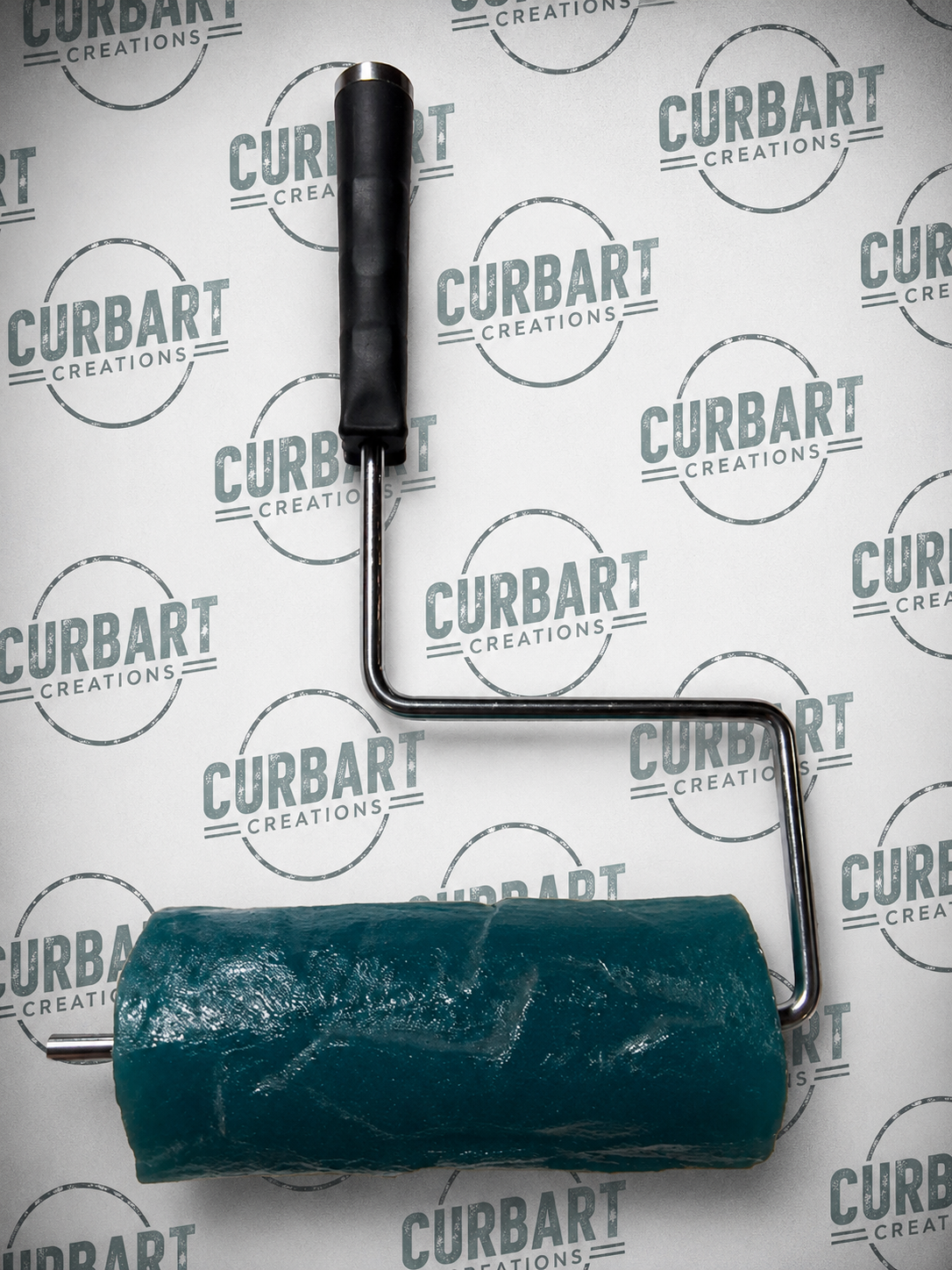 A slate roller with a dark teal green roller cover and a black handle, shown against a white background with a repeating 'CURBART CREATIONS' logo pattern.
