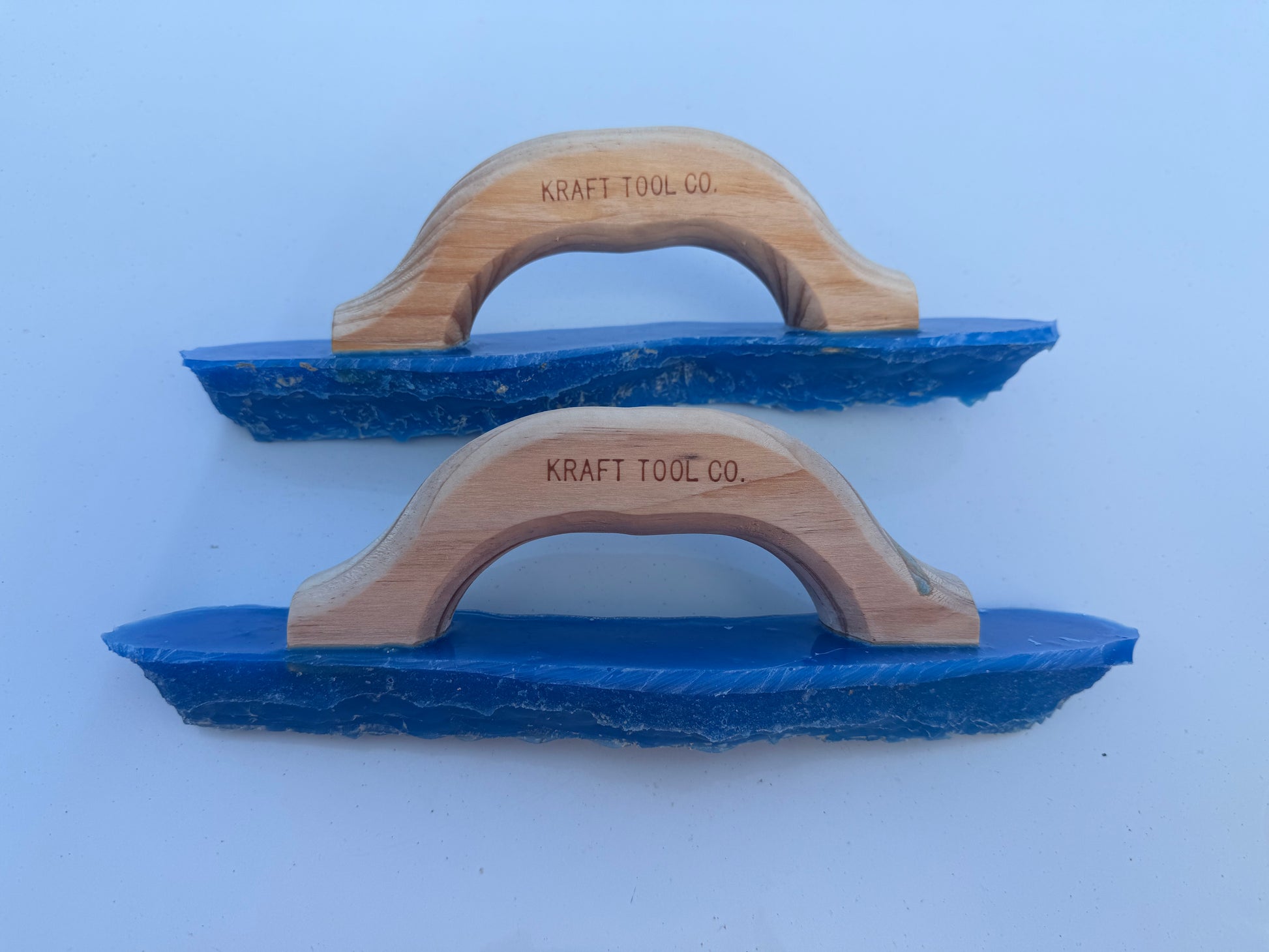 Two blue joint tools with wooden handles on a white background